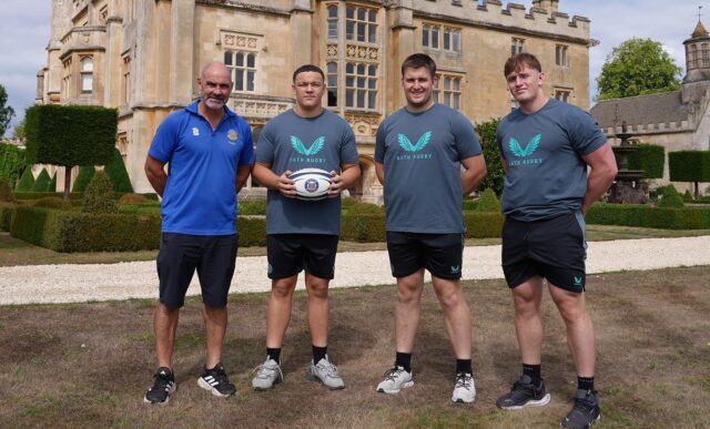 University of Bath Head of Rugby Aaron James with players Alfie Griffin, who is holding a rugby ball, Henry Mountford and Claudius Wheeler. They are stood out Farleigh House, Bath Rugby's headquarters.