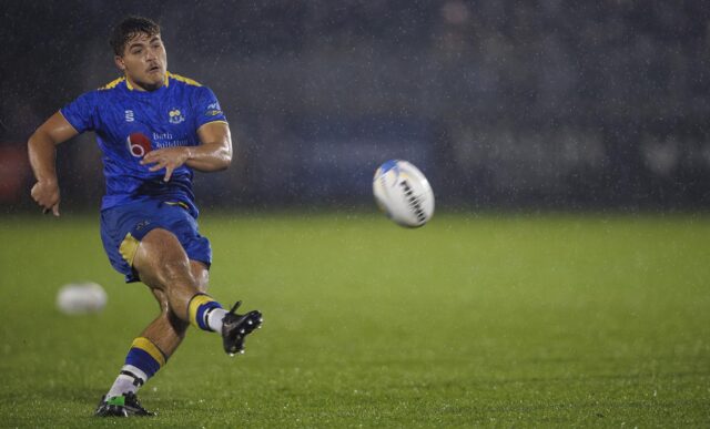 University of Bath men's 1st XV player Will Roue kicking a rugby ball with his right foot.