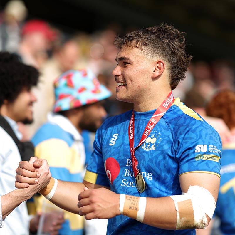 Will Roue, wearing a winner's medal around his neck, applauds the travelling Bath fans